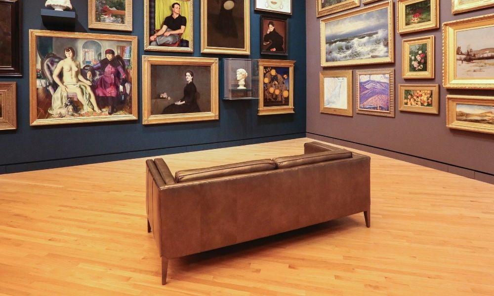 Photograph of a large leather sofa in the middle a room in an art gallery