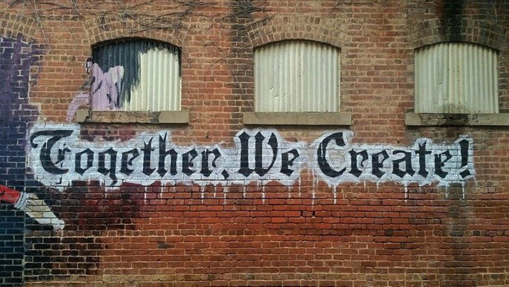 Graffiti sign saying 'Together, we create!'