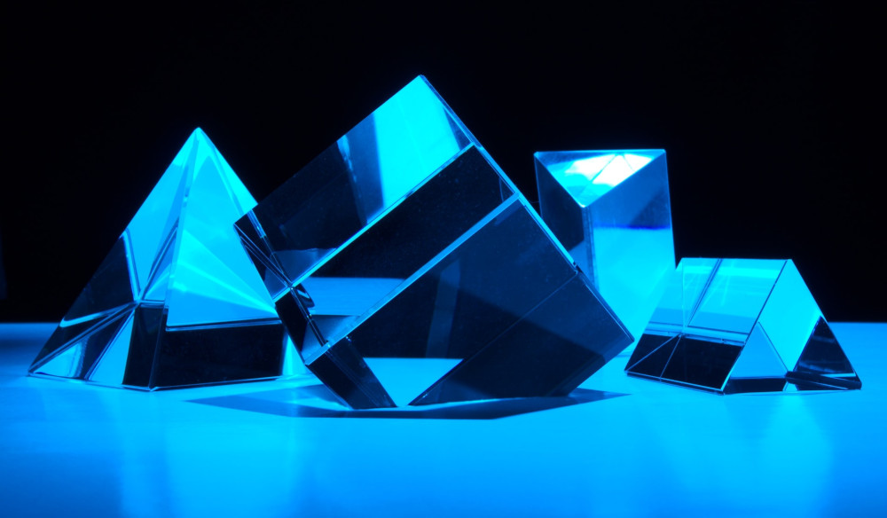 Prisms reflecting blue light on a black background