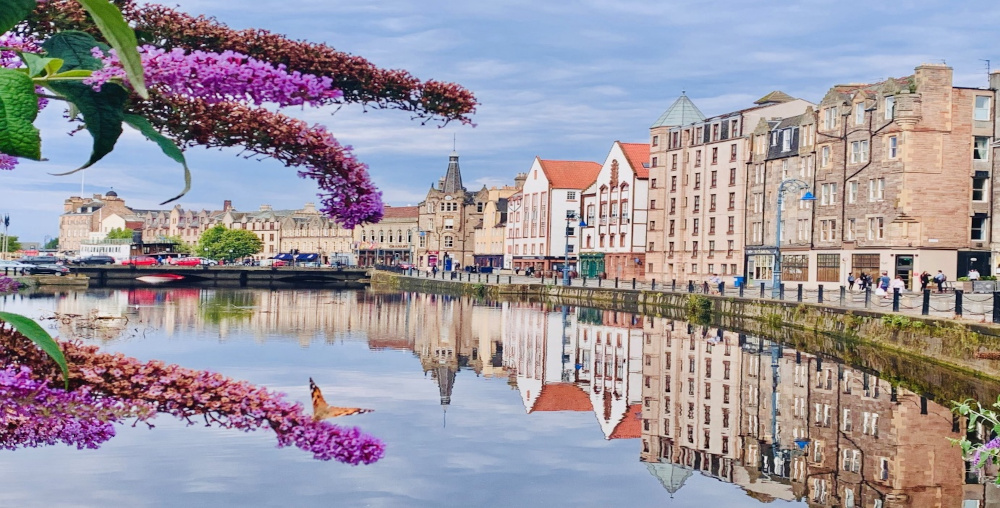 A photograph of Leith Shore, Edinburgh with the image of buildings reflecting on the waters