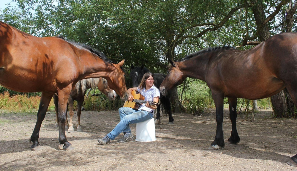 Photo credit: Ellen Cochrane of Gaia Horsemanship The image shows Glen's research collaborator Ellen Cochrane engaging in multi-species dialogue with a number of her equine friends. Ellen and Glen's work to explore the shift from the bit to the between, from domination to partnering, is grounded in principles of non-violent communication and are detailed in a recent paper in the Austral Journal of Veterinary Science (Cousquer, 2023). 
